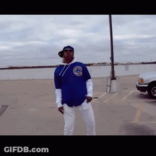 Man In Blue Chicago Cubs Jersey Standing In Parking Lot GIF