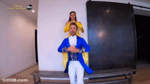 Man In Blue Coat Carrying Woman In Yellow Dress GIF