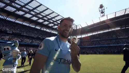 Man In Blue Etihad Airways Jersey Holding Medal GIF
