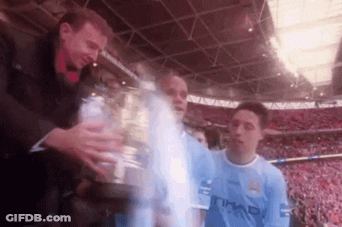 Man In Blue Etihad Shirt Holding Trophy GIF