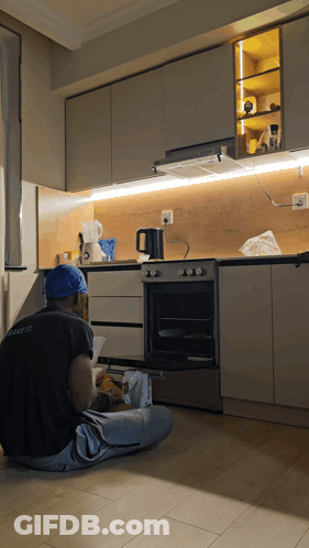 Man In Blue Hard Hat Fixing Kitchen Appliance GIF