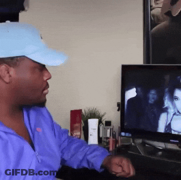 Man In Blue Hat And Purple Jacket Watching TV GIF