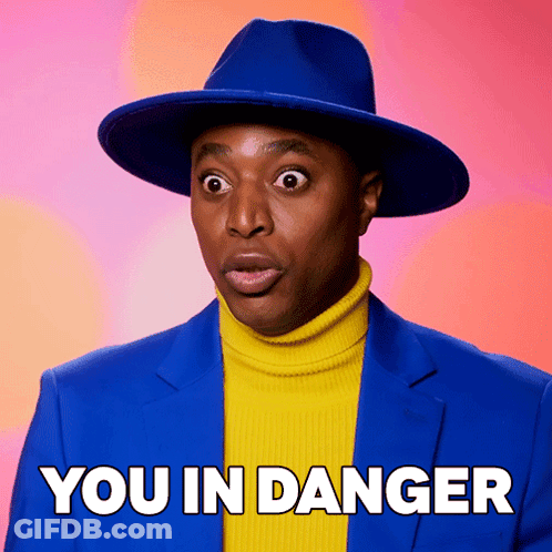 Man In Blue Hat And Yellow Turtleneck Saying You In Danger GIF