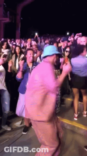 Man In Blue Hat Dancing In Front Of Crowd GIF