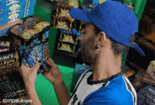 Man In Blue Hat Looking At Fireworks Box GIF