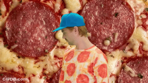 Man In Blue Hat Standing In Front Of Pizza GIF