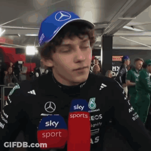 Man In Blue Hat With Mercedes Logo Talking Into Microphone For Sky Sports GIF