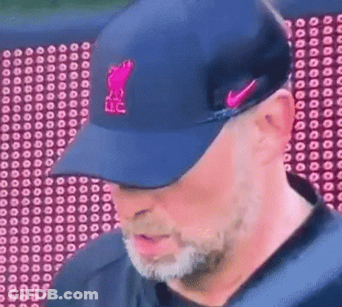 Man In Blue Hat With Pink Logo Looking Down GIF