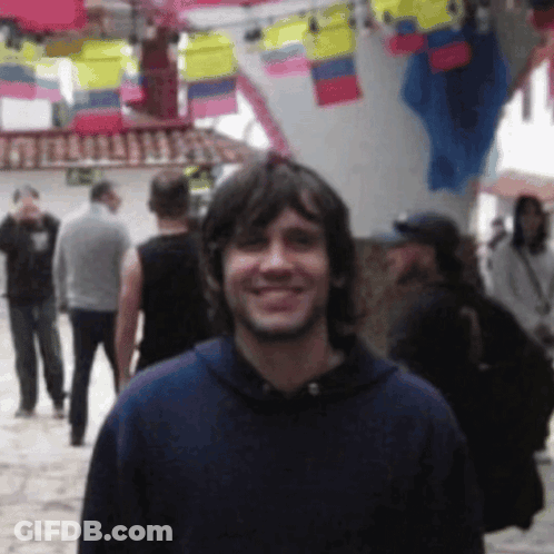 Man In Blue Hoodie Smiling In Crowd GIF