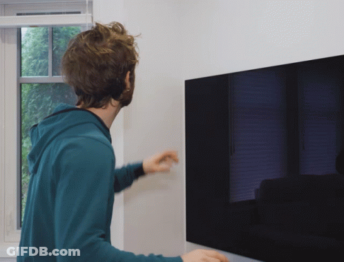 Man In Blue Hoodie Standing In Front Of TV GIF