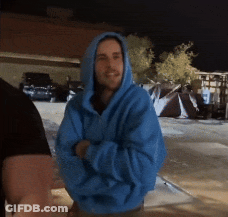 Man In Blue Hoodie Standing In Parking Lot GIF