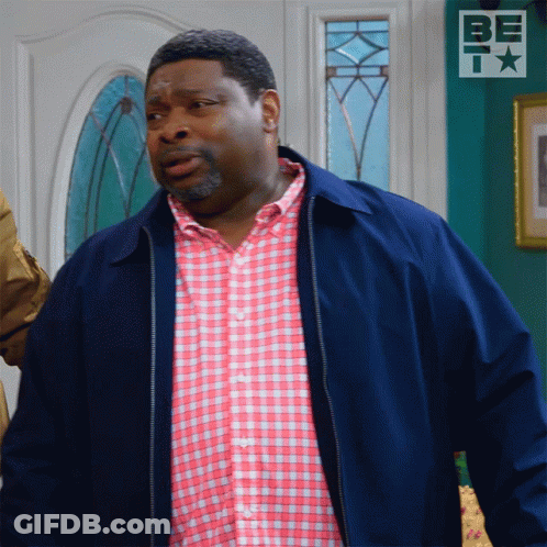 Man In Blue Jacket And Pink Plaid Shirt At Bet Sign GIF