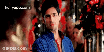 Man In Blue Jacket And Red Tie In Front Of Red Wall GIF