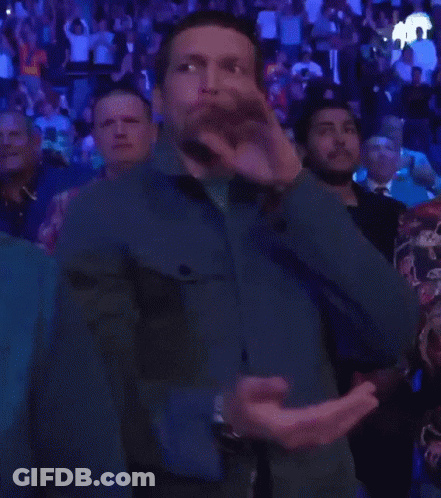 Man In Blue Jacket Applauding In Crowd GIF