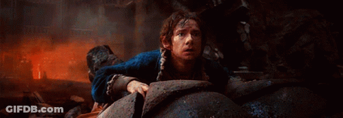 Man In Blue Jacket Crawling Through Rocks GIF