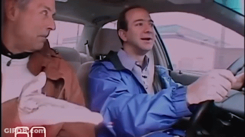 Man In Blue Jacket Driving Car Next To Man In Brown Jacket GIF