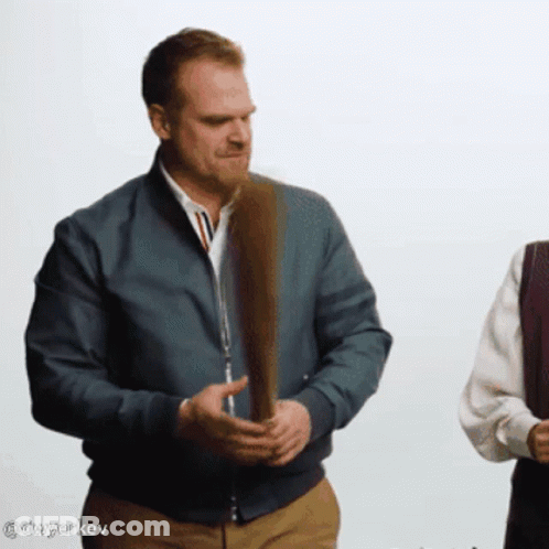 Man In Blue Jacket Holding Feather GIF