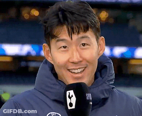 Man In Blue Jacket Holding Microphone With Tottenham Logo GIF