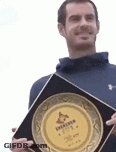 Man In Blue Jacket Holding Plaque GIF
