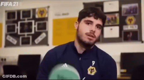 Man In Blue Jacket Holding Soccer Ball Talking GIF