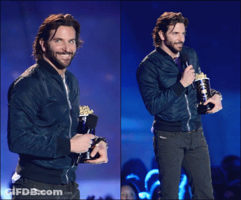 Man In Blue Jacket Holding Trophy And Microphone GIF