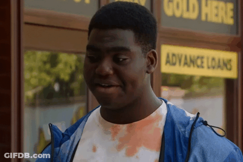 Man In Blue Jacket In Front Of Gold Loans Store GIF