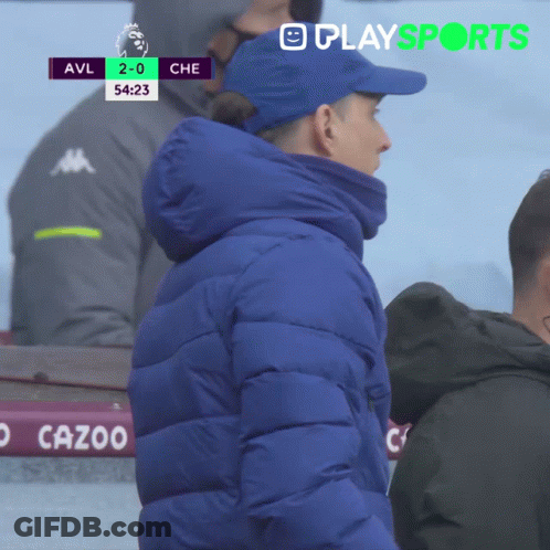 Man In Blue Jacket In Front Of Scoreboard GIF