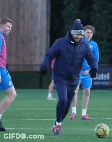 Man In Blue Jacket Kicking Soccer Ball GIF