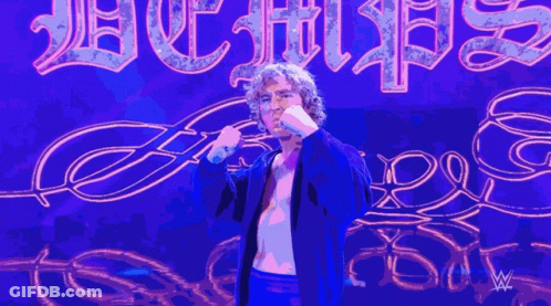 Man In Blue Jacket Next To Purple Hurricanes Sign GIF