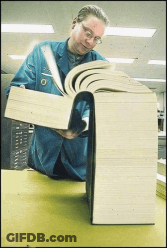 Man In Blue Jacket Reading Very Large Book GIF