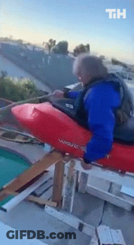 Man In Blue Jacket Riding Red Wave Kayak On Rooftop GIF
