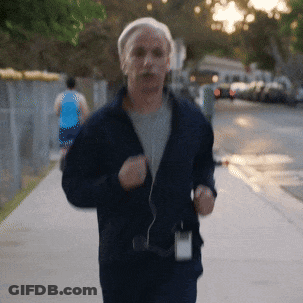 Man In Blue Jacket Running Down Sidewalk GIF