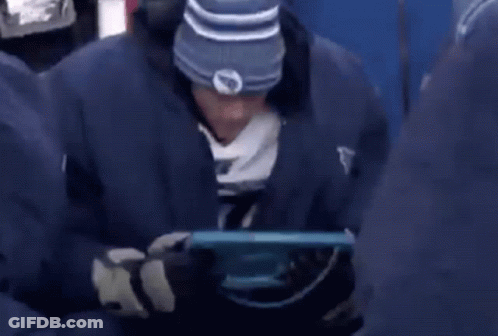 Man In Blue Jacket Saying Titans Looking At Tablet GIF