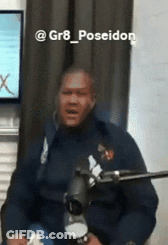 Man In Blue Jacket Sitting At Microphone Poseidon GIF