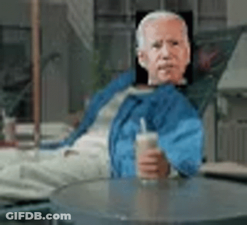 Man In Blue Jacket Sitting At Table With Drink GIF