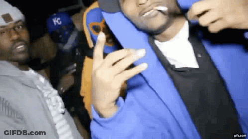 Man In Blue Jacket Smoking And Posing With Another Man GIF