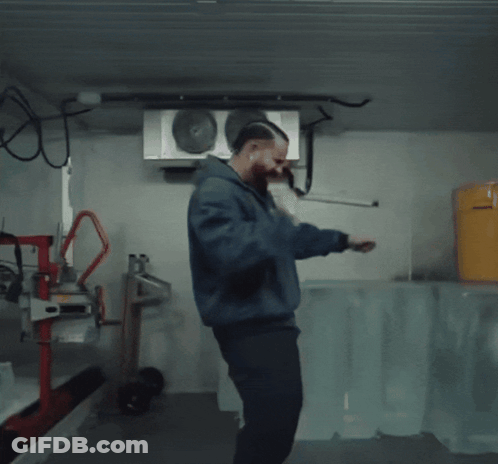 Man In Blue Jacket Squatting With Yellow Bucket GIF