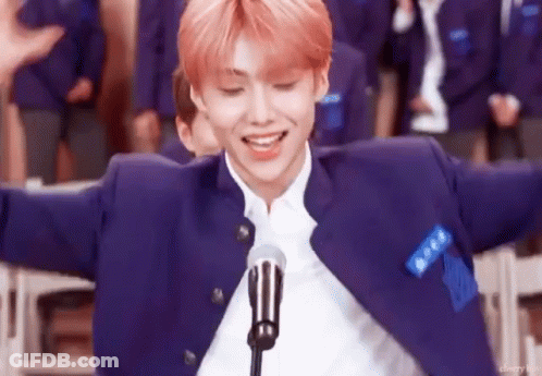 Man In Blue Jacket Standing At Microphone With Arms Outstretched GIF