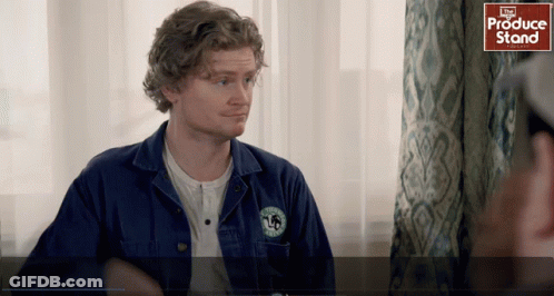 Man In Blue Jacket Standing By Produce Stand GIF