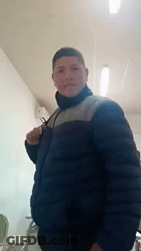 Man In Blue Jacket Standing In Room With Chairs GIF