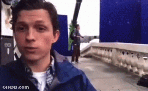 Man In Blue Jacket Standing On Sidewalk GIF