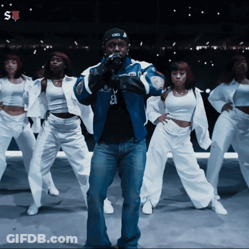 Man In Blue Jacket Surrounded By Female Dancers GIF