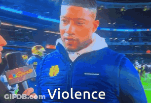 Man In Blue Jacket Talking Into Microphone With Violence GIF