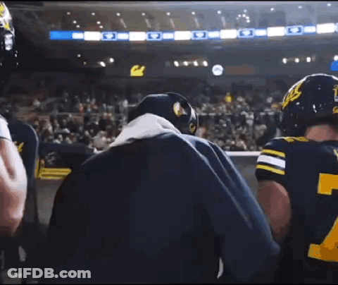 Man In Blue Jacket Talking To Football Player GIF