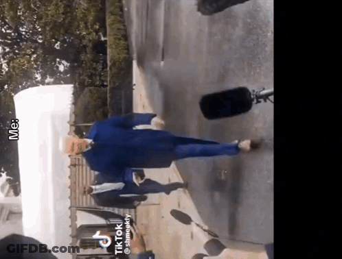 Man In Blue Jacket Walking Down Street GIF