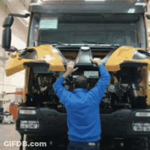 Man In Blue Jacket Working On Truck With Hood Open GIF