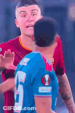 Man In Blue Jersey Hugging Man In Red Shirt GIF