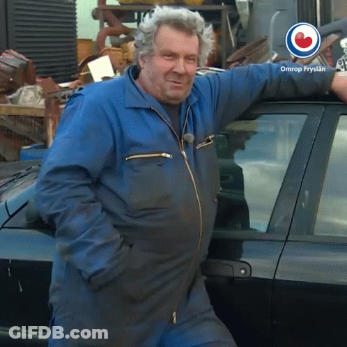 Man In Blue Jumpsuit Leaning Against Black Car Omrop Fryslan GIF