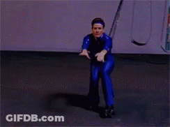 Man In Blue Jumpsuit Standing In Rain With Hands Up GIF