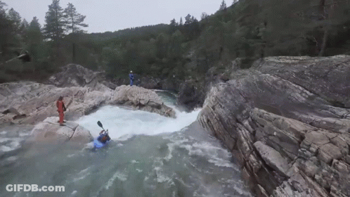 Man In Blue Kayak Going Through Waterfall GIF